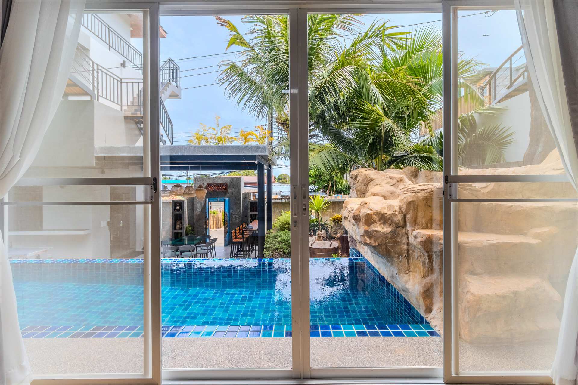 Evening view of illuminated swimming pool with ambient lighting and pool deck