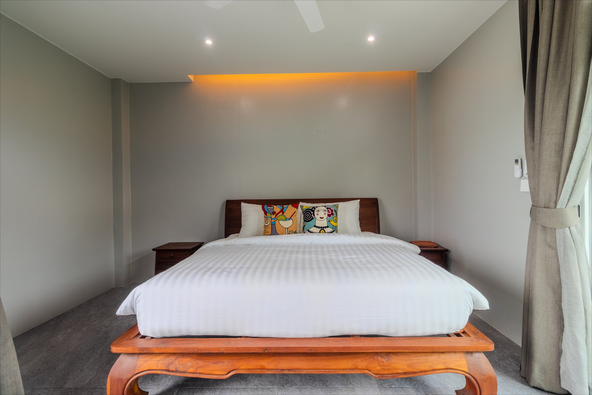 Minimalist king bedroom with warm LED backlighting and artisan throw cushions