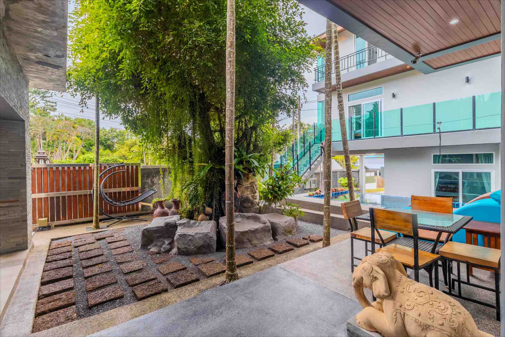 Outdoor lounge and relaxation area surrounded by tropical plants and water features
