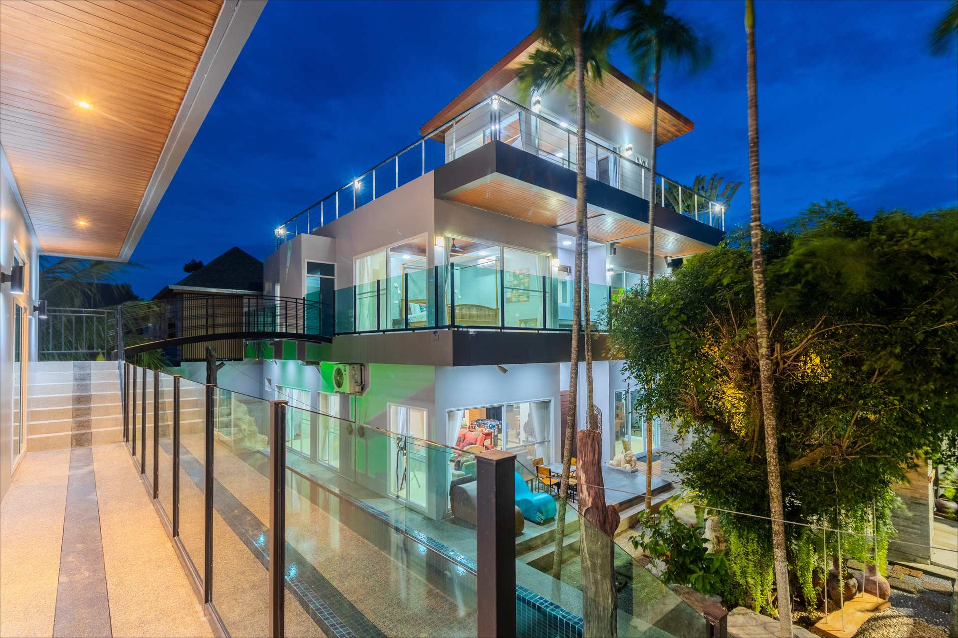 Front facade of the 10 Bed Phuket Villa luxury estate at sunset with illuminated pathways